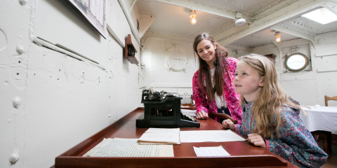 Mother and daughter next to the captain's desk in his quarters aboard HMS Caroline
