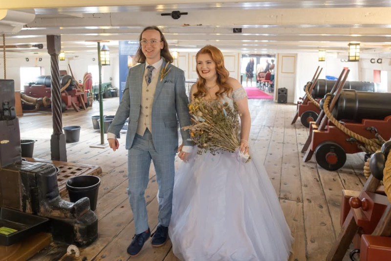 Wedding couple walking along HMS Trincomalee