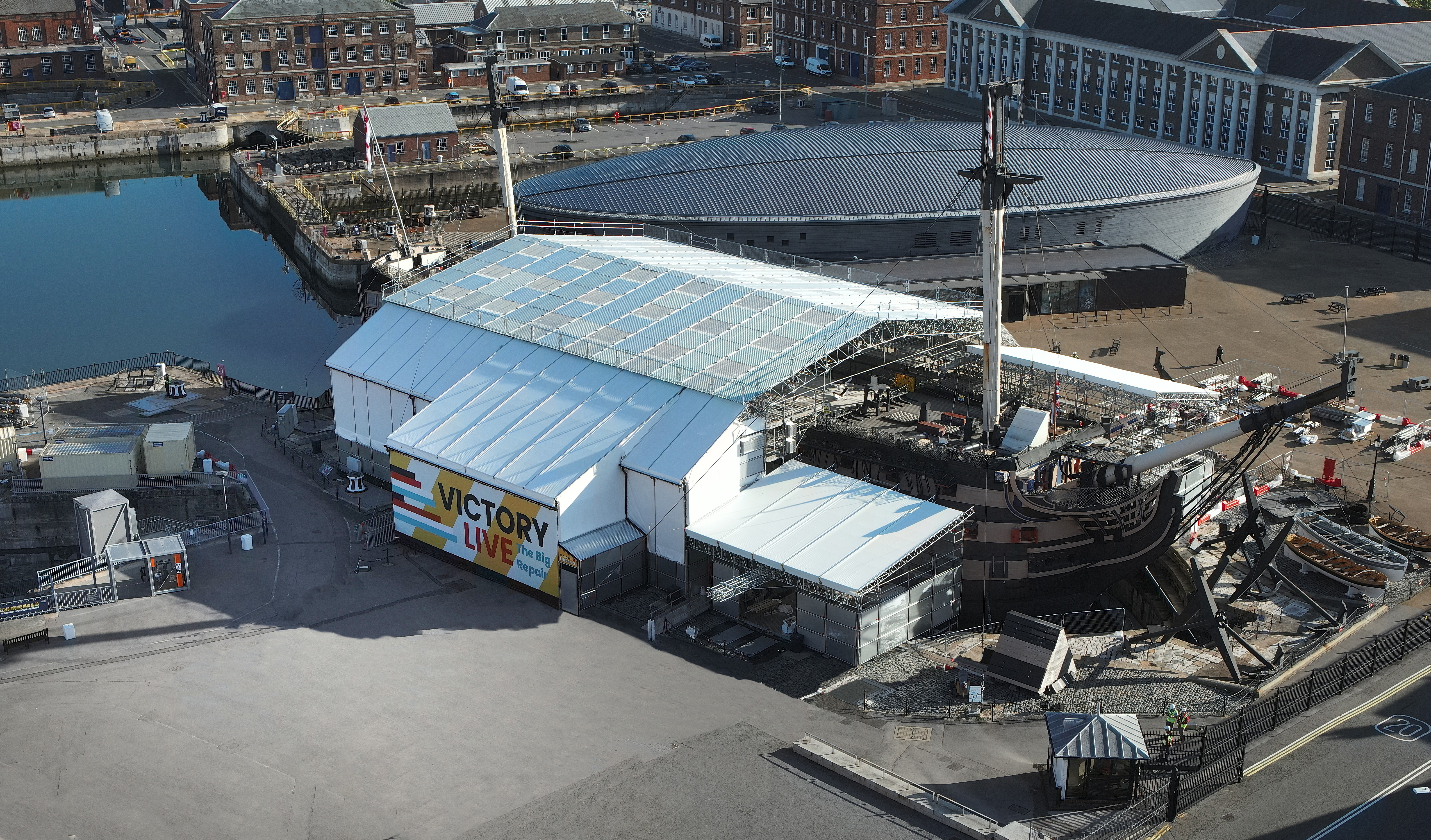 A modern aerial photograph of a Napoleonic-era ship covered in a tent to enable conservation works