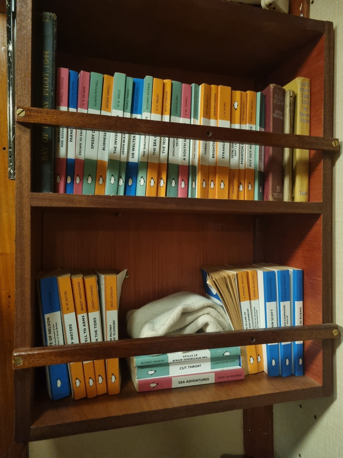A wooden shelf of old Penguin books