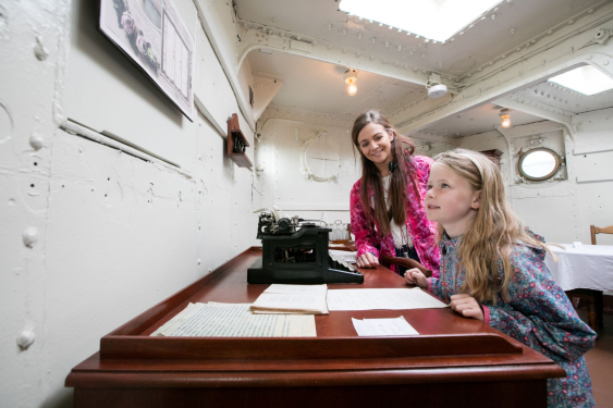 Mother and daughter next to the captain's desk in his quarters aboard HMS Caroline