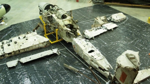 Wreckage of aircraft laid out on floor
