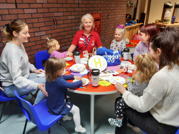 Parents and toddlers sitting around a table taking part in activities