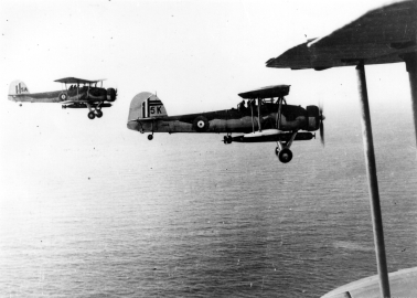 A black and white image of to Swordfish aircraft flying