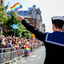 A sailor waves a pride flag Credit Royal Navy LGBTQ+ Network