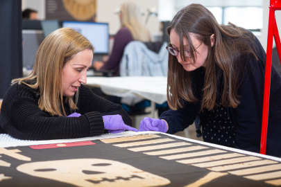 Curators inspect a Jolly Roger