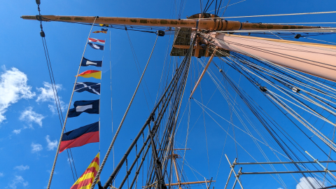 Semaphore flags on HMS Warrior spelling 'Play Up Pompey'