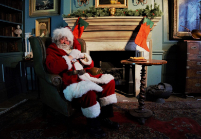 Santa Claus relaxing in a recreation of a Georgian study, complete with stockings above the fireplace. The study is part of a recreated Georgian quayside at the National Museum of the Royal Navy Hartlepool