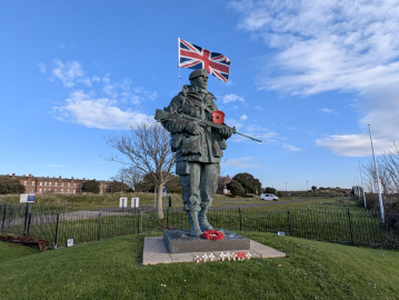 A large bronze statue of a Royal Marine with a Union Jack coming out of his backpack