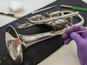 musical instrument (trumpet or cornet being worked on