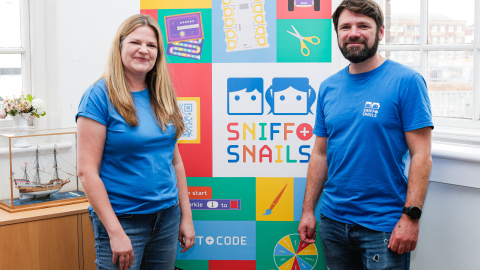 sniff and snails staff in front of banner with event resources