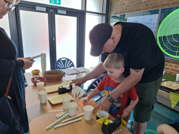 man and boy creating at table