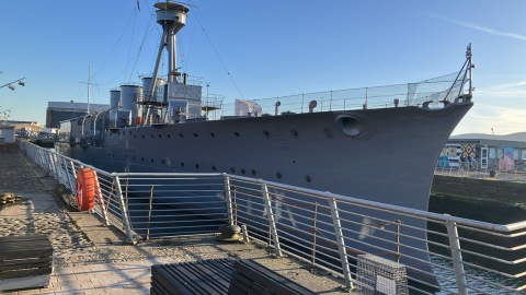 HMS Caroline shown in dock on a clear day