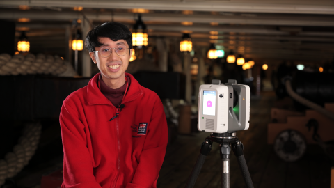 A man sat onboard HMS Victory with a camera for scanning