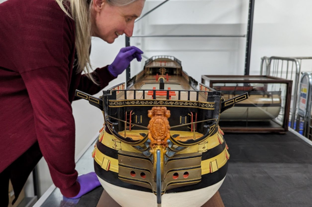 A scale-model of HMS Victory is examined by Principal Curator Victoria Ingles