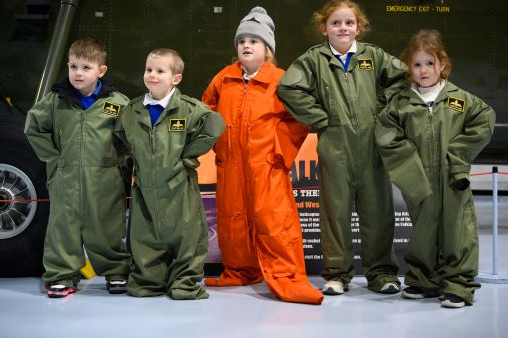 Five children wear mini versions of Royal Air Force jumpsuits.