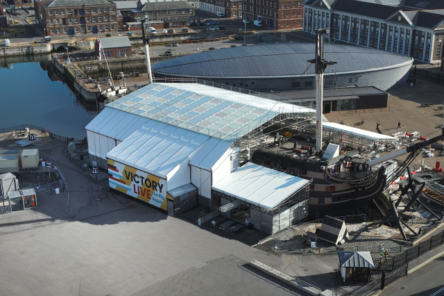 A modern aerial photograph of a Napoleonic-era ship covered in a tent to enable conservation works