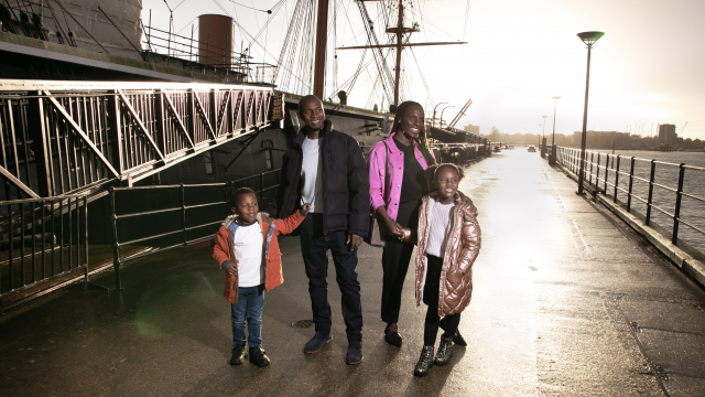 Family standing in front of HMS Warrior