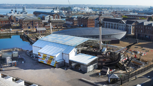 An 18th century warship encased in scaffolding and plastic covers indicating conservation work is ongoing