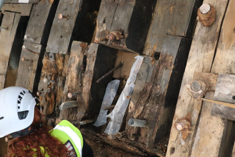 HMS Victory’s conservator attaching the supportive paper strips.