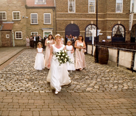 Bridal party walking on quayside towards HMS Trincomalee