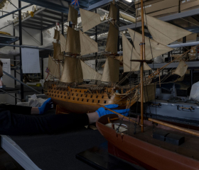 Curator holding model ship