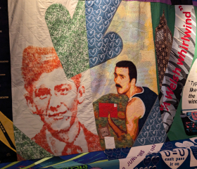 A close-up on a colourful quilt featuring images of the same man at two different ages