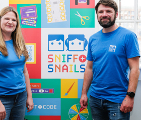 Sniff and Snails staff in front of banner with event resources.