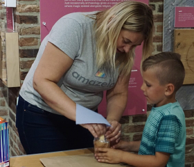 Instructor and child working on project together.