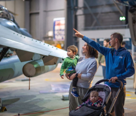 family of 4 with young children looking at the planes on display