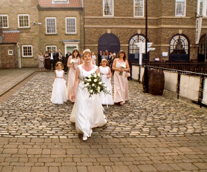 Bridal party walking on quayside towards HMS Trincomalee