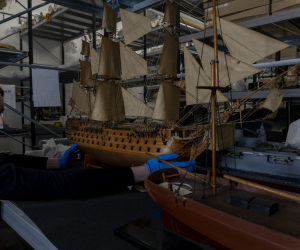 Curator holding model ship