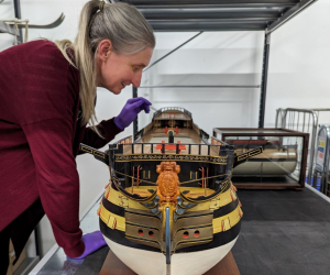 A scale-model of HMS Victory is examined by Principal Curator Victoria Ingles