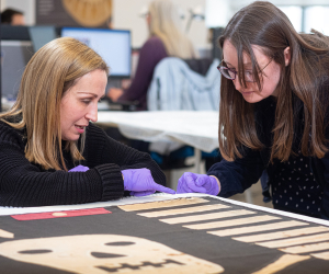 Curators inspect a Jolly Roger