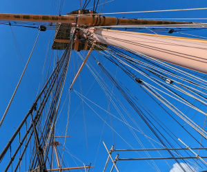 Semaphore flags on HMS Warrior spelling 'Play Up Pompey'