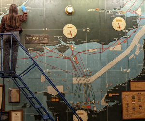 A conservator works at height conserving the D-Day map