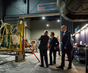 Three figures look on at the ongoing work to rebuild a Fairey Barracuda