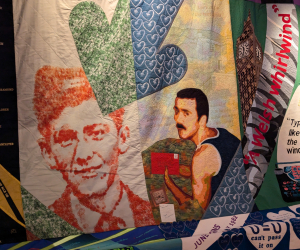 A close-up on a colourful quilt featuring images of the same man at two different ages