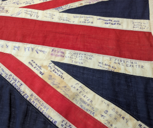 A close-up of a Union Jack flag with many names written on it