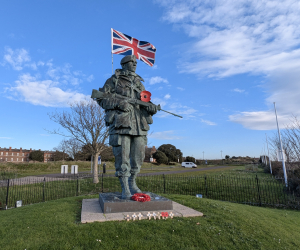 A large bronze statue of a Royal Marine with a Union Jack coming out of his backpack