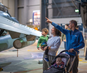family of 4 with young children looking at the planes on display