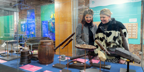 Two women looking at the Diving Deep HMS Invincible 1744 exhibition