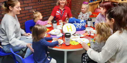 Parents and toddlers sitting around a table taking part in activities