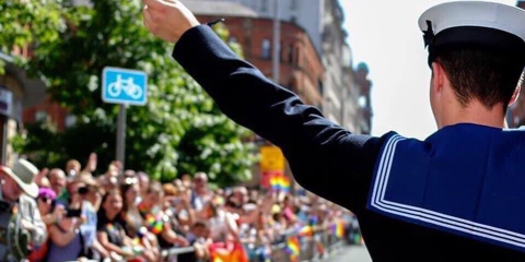 A sailor waves a pride flag Credit Royal Navy LGBTQ+ Network